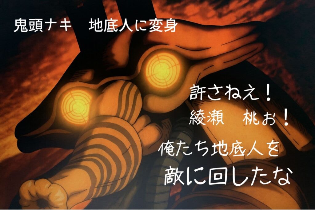 赤く燃えるような背景の中、地底人のような異形の存在が正面を見据えている。顔は黒くぬめった質感で、光を放つ3つの丸い目が特徴的。鼻からは象のように長く伸びた器官が垂れ下がり、胴体は太いケーブルや装甲で覆われている。威圧感と異質さが際立つデザイン。